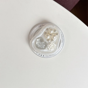 Macro shot of heart-shaped magnetic phone grip with pearls, flowers and resin gems
