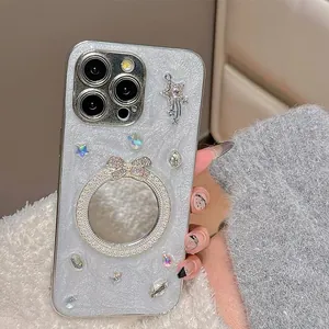 Dettaglio custodia iPhone glitterata con specchio a fiocco e ciondoli stella strass