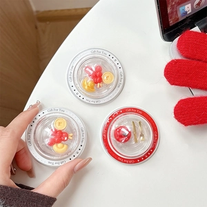 Three acrylic phone grip charms with red berries and golden ingots on white background