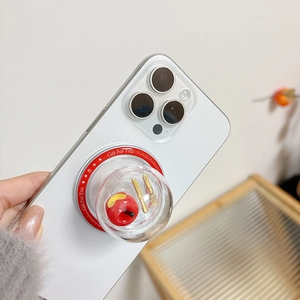Close-up of a creative phone socket featuring a mini apple and gold cutlery in a clear dome