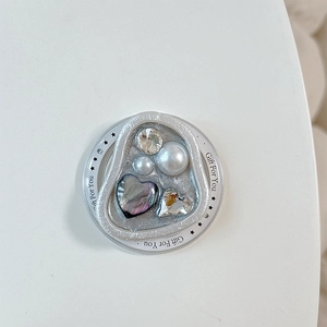 Dettaglio del supporto magnetico per telefono con perle, cristalli e intarsio cuore