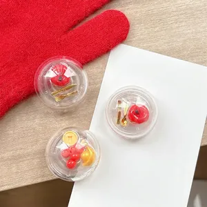Spherical phone grip with miniature lucky red fruit and gold coins in a transparent shell