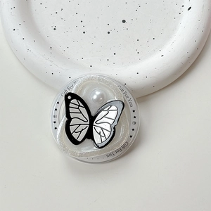 Macro shot of butterfly phone grip with white pearl on a ceramic plate, Gift For You text