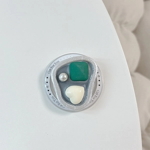Dettaglio del supporto magnetico per telefono con gemma verde, cuore e perla su argento