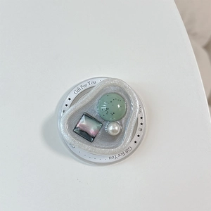 Dettaglio del supporto magnetico con resina maculata verde, perla e base con glitter argento