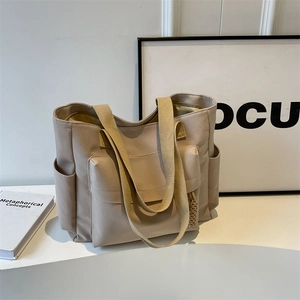 Retro canvas tote bag in beige featuring large front pocket and side compartments