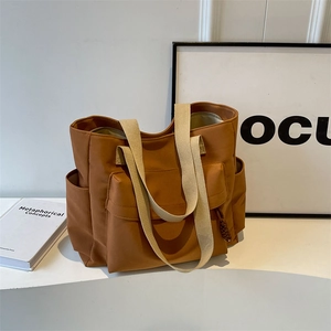 Brown canvas tote bag with wide white strap and large capacity for daily commuting