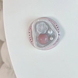 Dettaglio macro del supporto magnetico con rosa 3D, gemma rosa e perle eleganti