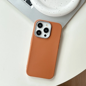 Detail der iPhone-Hülle aus karamellfarbenem Leder mit silbernem Metallrahmen für Kameras
