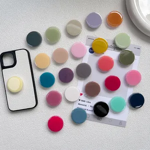 Various Morandi colors round collapsible phone grip stands on white leather case