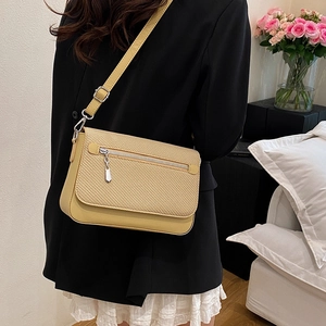 Beige woven texture crossbody bag with front zipper pocket and adjustable shoulder strap