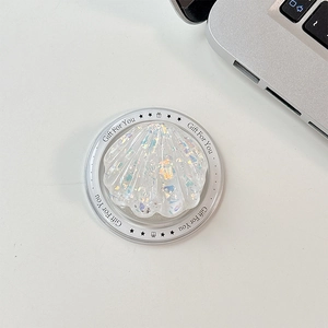 Close-up of shell-shaped phone grip with colorful sequins on a Gift For You display card