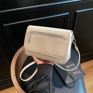 Chic beige textured crossbody bag with silver zipper detail and woven flap for women