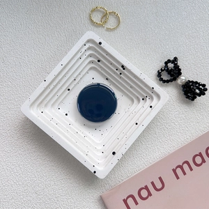 Detail of a dark blue glossy pop-up phone socket on a white minimalist display tray