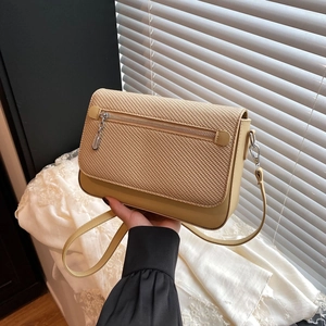 Beige crossbody bag with woven texture flap and silver metal zipper detailing