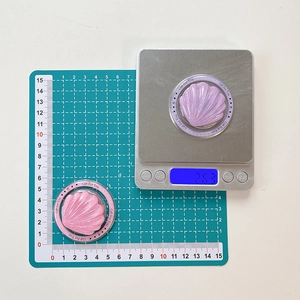 Macro detail of seashell magnetic phone stand with glitter texture on weight scale