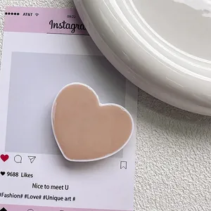 Gros plan du support de téléphone en forme de cœur rose poudré avec finition résine