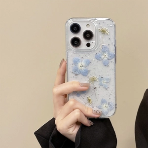 Transparent iPhone case with blue dried flowers and silver foil flakes, floral design