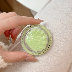 Macro shot of light green glitter shell phone grip with Magsafe magnetic base in hand