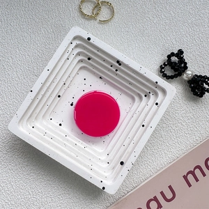 Flat lay of a hot pink pop socket on a terrazzo tray with jewelry accessories