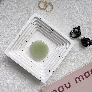 Macro detail of a pale green round jade phone socket on a stylish textured tray