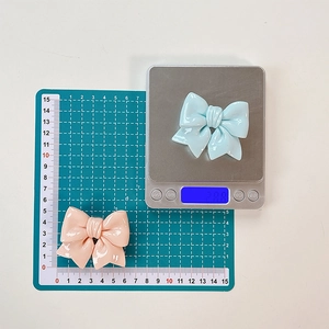 Detail showing dimensions and 2.8g weight of blue and pink bow retractable phone stands