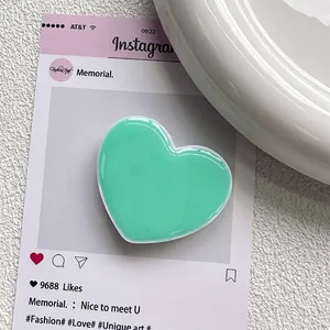 Détail du support de téléphone cœur vert menthe avec finition brillante sur fond blanc
