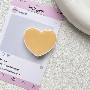 Détail d'un support de téléphone en forme de cœur avec finition brillante sur fond épuré