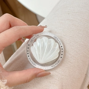 Detailed view of MagSafe phone grip with pearlescent shell inlay and Gift For You text