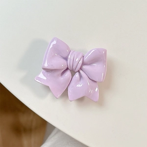 Close-up of glossy purple bow phone grip with a polished resin finish on white backdrop