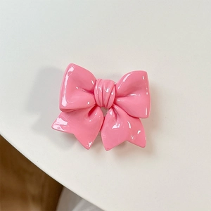 Detail of glossy bright pink bow grip for phone back with smooth resin texture finish