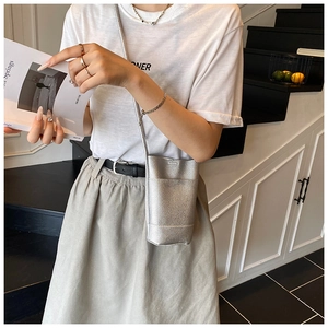 Detail view of silver textured leather mini crossbody bag with sleek metal chain strap