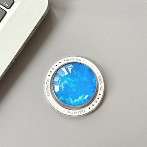Detail of magnetic star nebula phone socket with Gift For You print on a gray desk