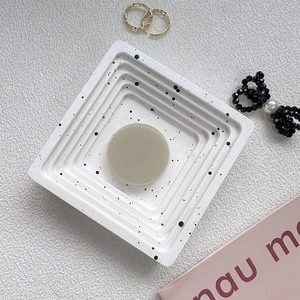 Detail view of square marble textured tray with a round beige pop socket phone stand