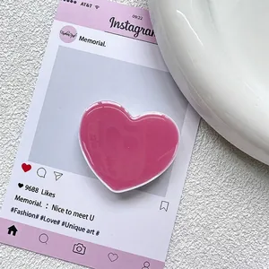 Vue macro du support de téléphone en forme de cœur rose pêche avec une finition brillante