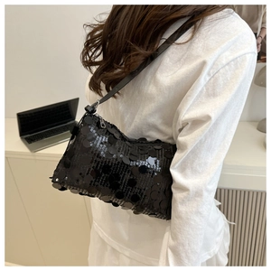 Detail view of the black sequin shoulder bag on model with glossy reflective finish