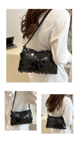 Detailed view of black sequined crossbody bag with silver zipper and leather strap