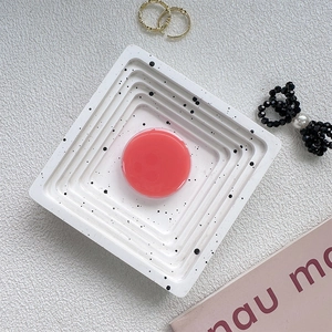 Detailed top view of a translucent pink round phone grip on a white speckled ceramic tray