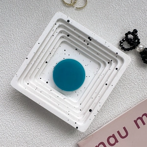 Macro view of a round teal blue pop socket phone grip on a white speckled tray