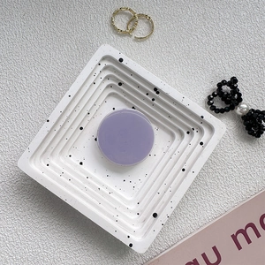 Minimalist purple circular phone socket mount on a decorative white textured tray