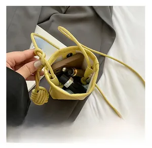 Detail showing the internal capacity of this yellow mini leather bucket bag with items