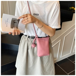 Detail of pink lychee leather phone bag featuring a stylish knotted shoulder strap detail