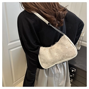Detail showing grey textured sequin shoulder bag with silver chain on model indoors
