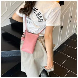 Pink lychee texture mini crossbody phone bag with knot detail shown on model