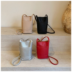Detailed view of four mini bucket bags in beige black silver and red leather
