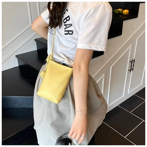 Detail of yellow lychee texture leather mini crossbody phone bag with knot strap
