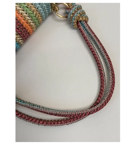 Detail of colorful woven shoulder bag with gold metal ring and braided rope strap