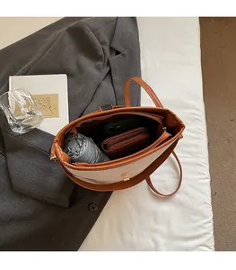 Top view of spacious bucket bag interior with a phone, umbrella, and brown wallet