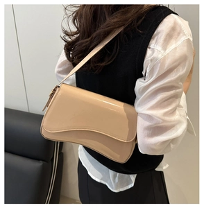 Detail of a chic beige patent leather shoulder bag showing its glossy finish and sleek flap