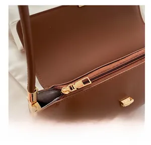 Close-up of caramel brown retro underarm bag showing smooth zipper and gold hardware